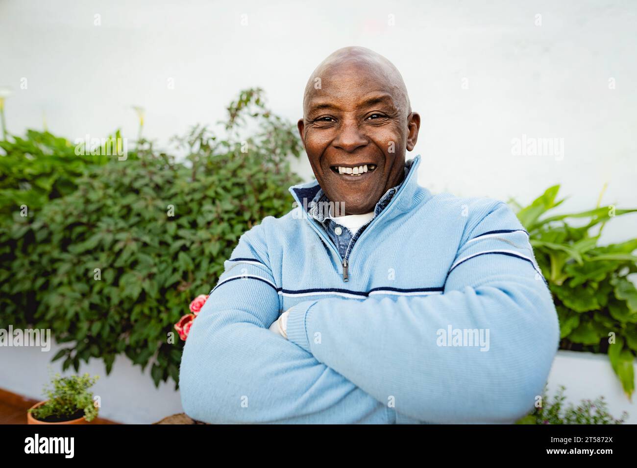 Felice uomo africano anziano che giardinaggio a casa Foto Stock