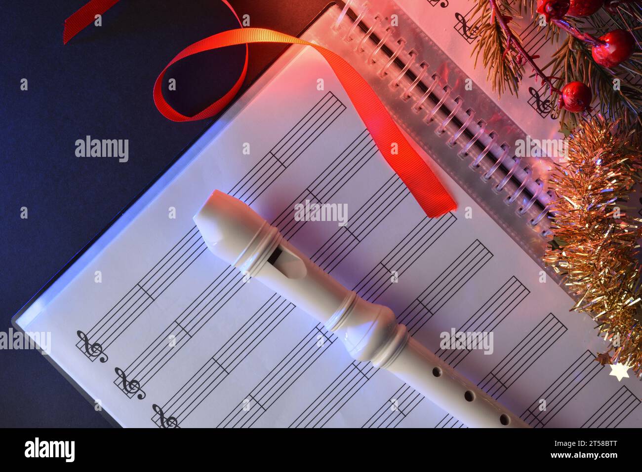 Registratore di plastica tradizionale su una cartella di spartiti su un tavolo nero con decorazioni natalizie. Vista dall'alto. Foto Stock
