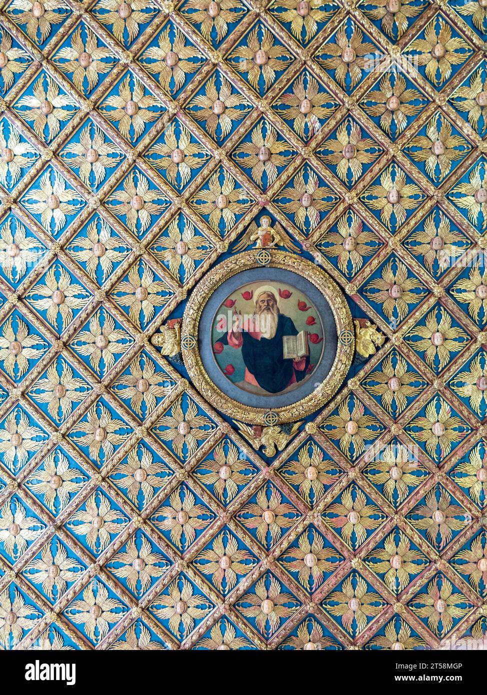 Sezione del soffitto riccamente decorata. Al centro un'immagine di un santo che tiene la Bibbia. Pattern ripetuti a 360°. Foto Stock