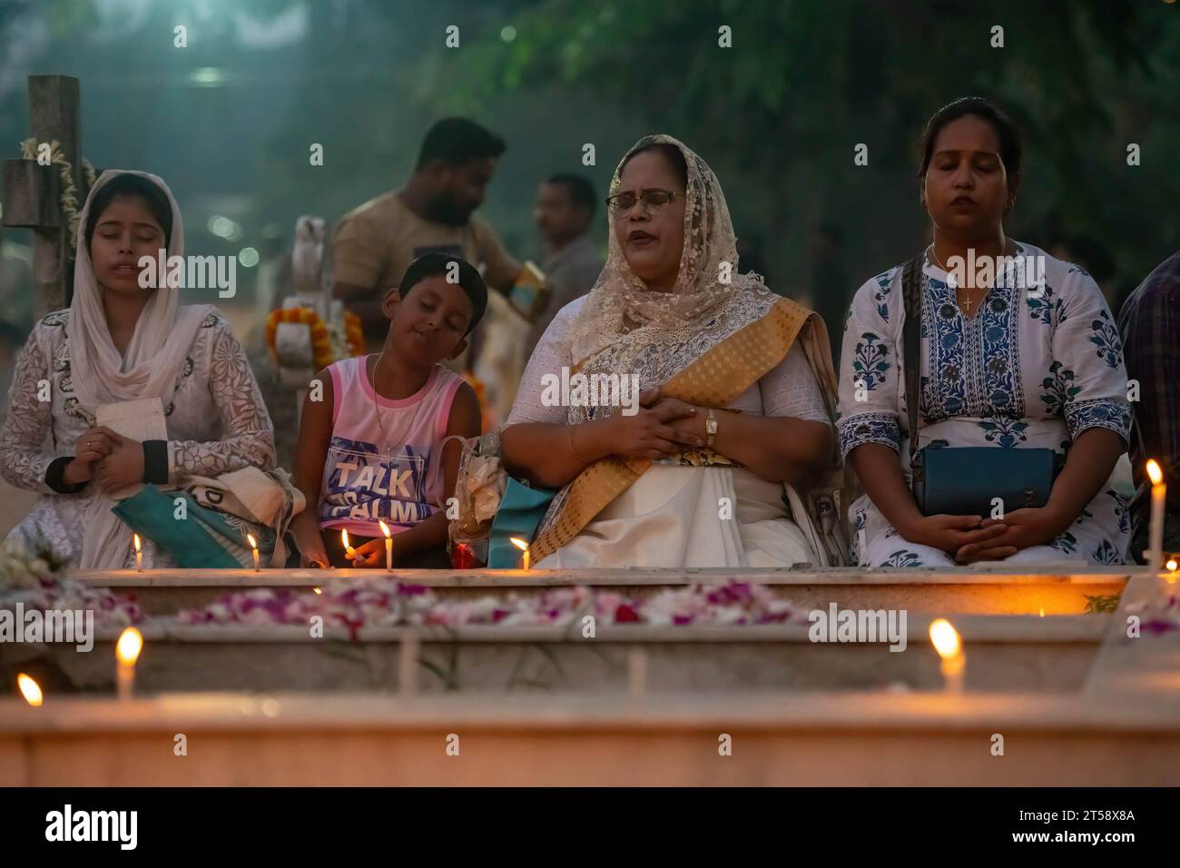 Kolkata, India. 2 novembre 2023. Una famiglia cattolica indiana ha acceso le candele, pregate per i loro parenti defunti durante la commemorazione di All Souls' Day in un cimitero. I cattolici indiani accendono le candele per i loro parenti defunti durante la commemorazione di All Souls' Day in un cimitero, in questo giorno i cattolici pregano per i morti. Credito: SOPA Images Limited/Alamy Live News Foto Stock