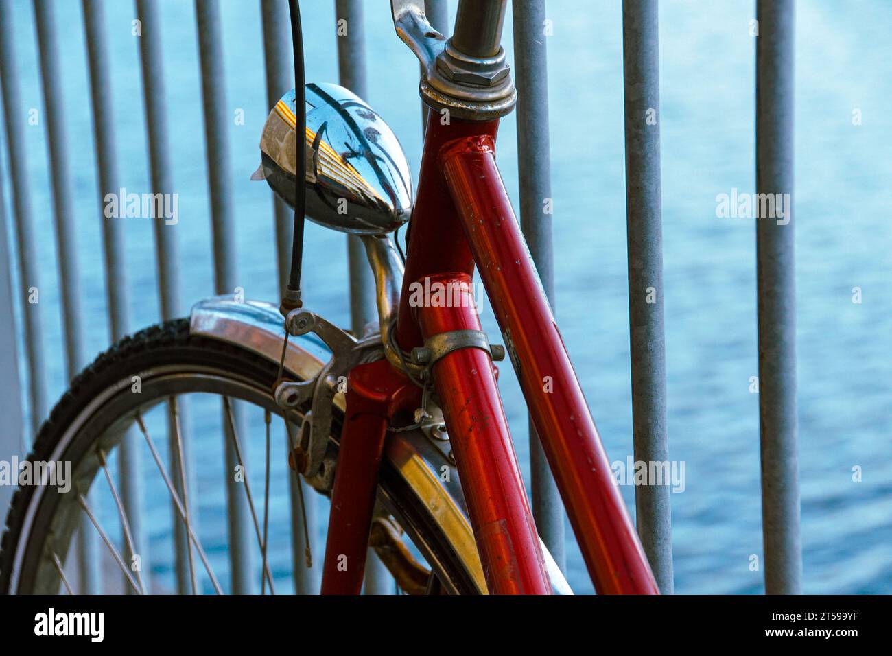 una bicicletta si appoggia contro la recinzione Foto Stock