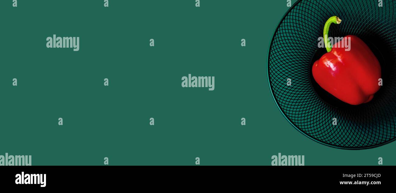 Carta da parati minimalista con pepe di paprika su uno sfondo solido e scuro. Copia spazio. Modernità, risorse alimentari, sostenibilità, creatività Foto Stock