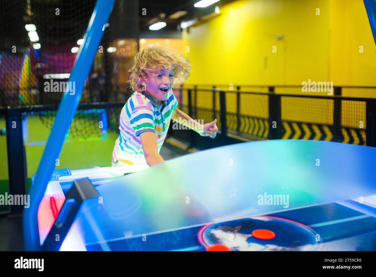 I bambini giocano a hockey su aria. Divertenti giochi arcade. Bambini al parco divertimenti. Parco giochi al coperto per famiglie. Foto Stock