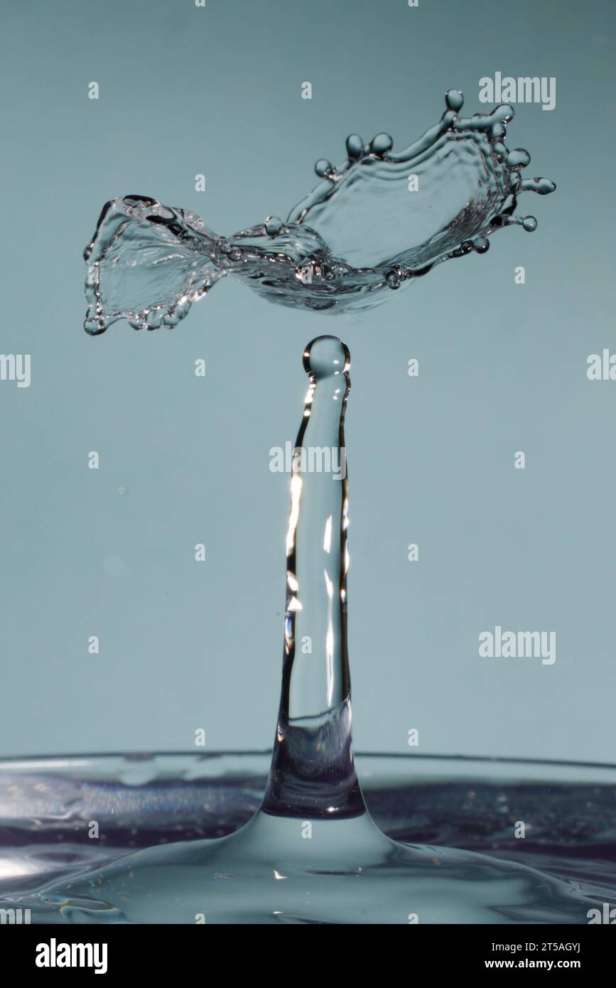 due gocce d'acqua si scontrano e causano schizzi con la corona e picchi Foto Stock