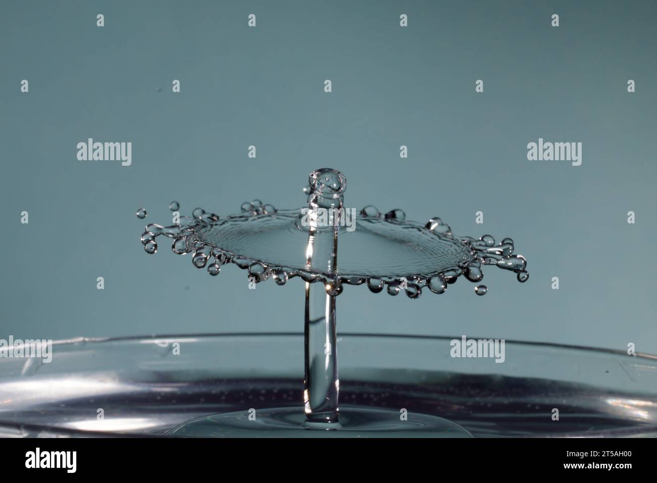 due gocce d'acqua si scontrano e causano schizzi con la corona e picchi Foto Stock