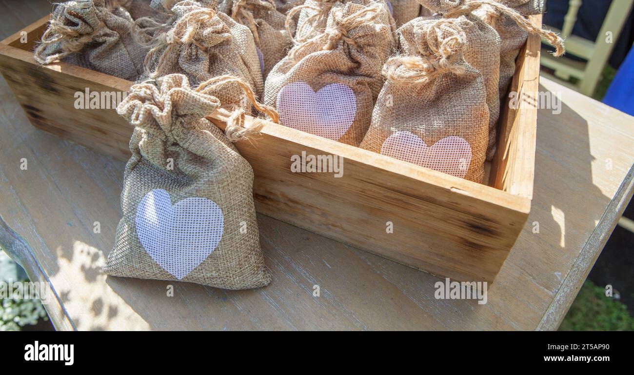 Bustine di riso pronte da gettare via dopo una cerimonia nuziale. Contenitore in legno Foto Stock