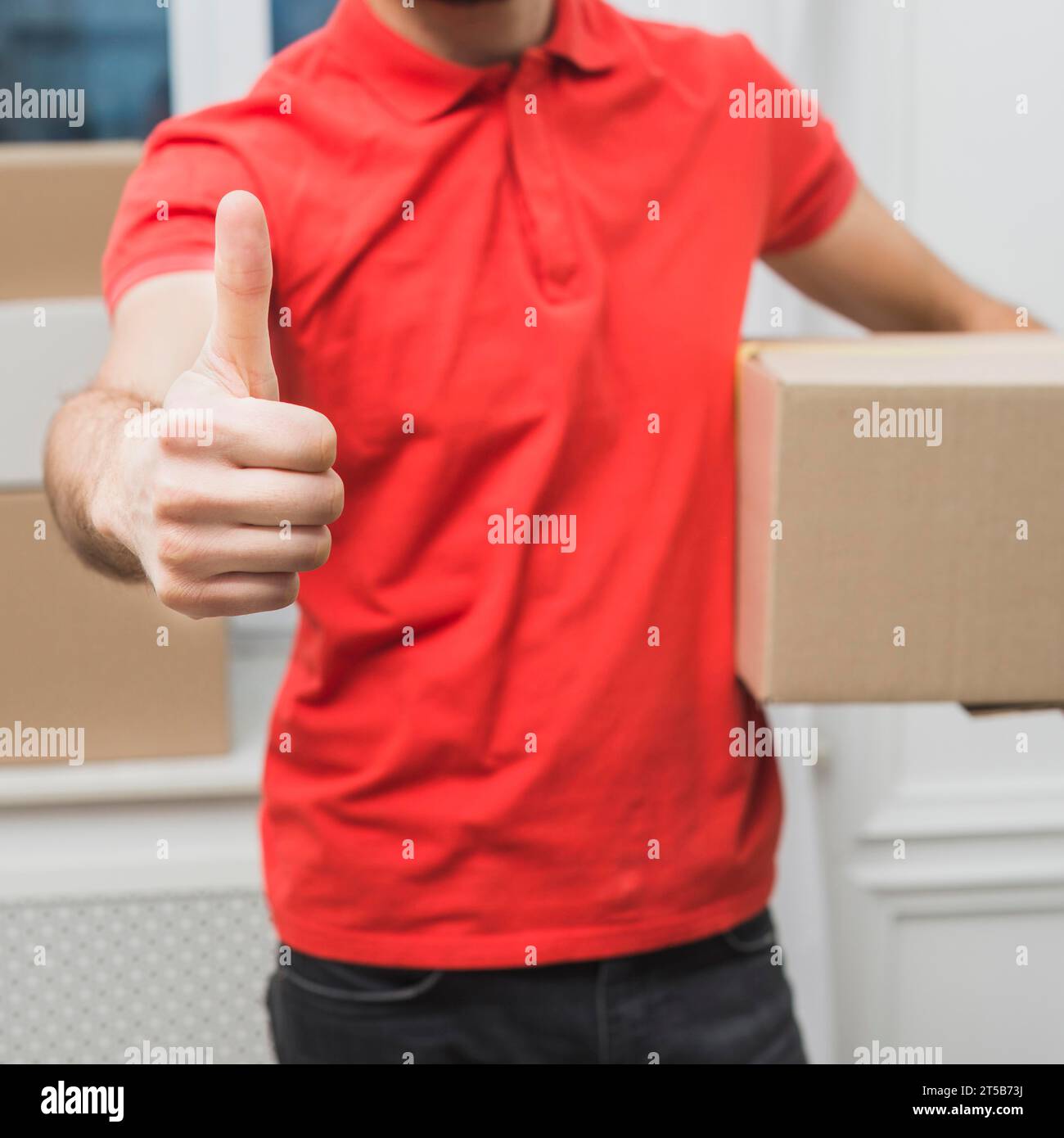 Pollice verso l'alto del corriere per la movimentazione del prodotto Foto Stock