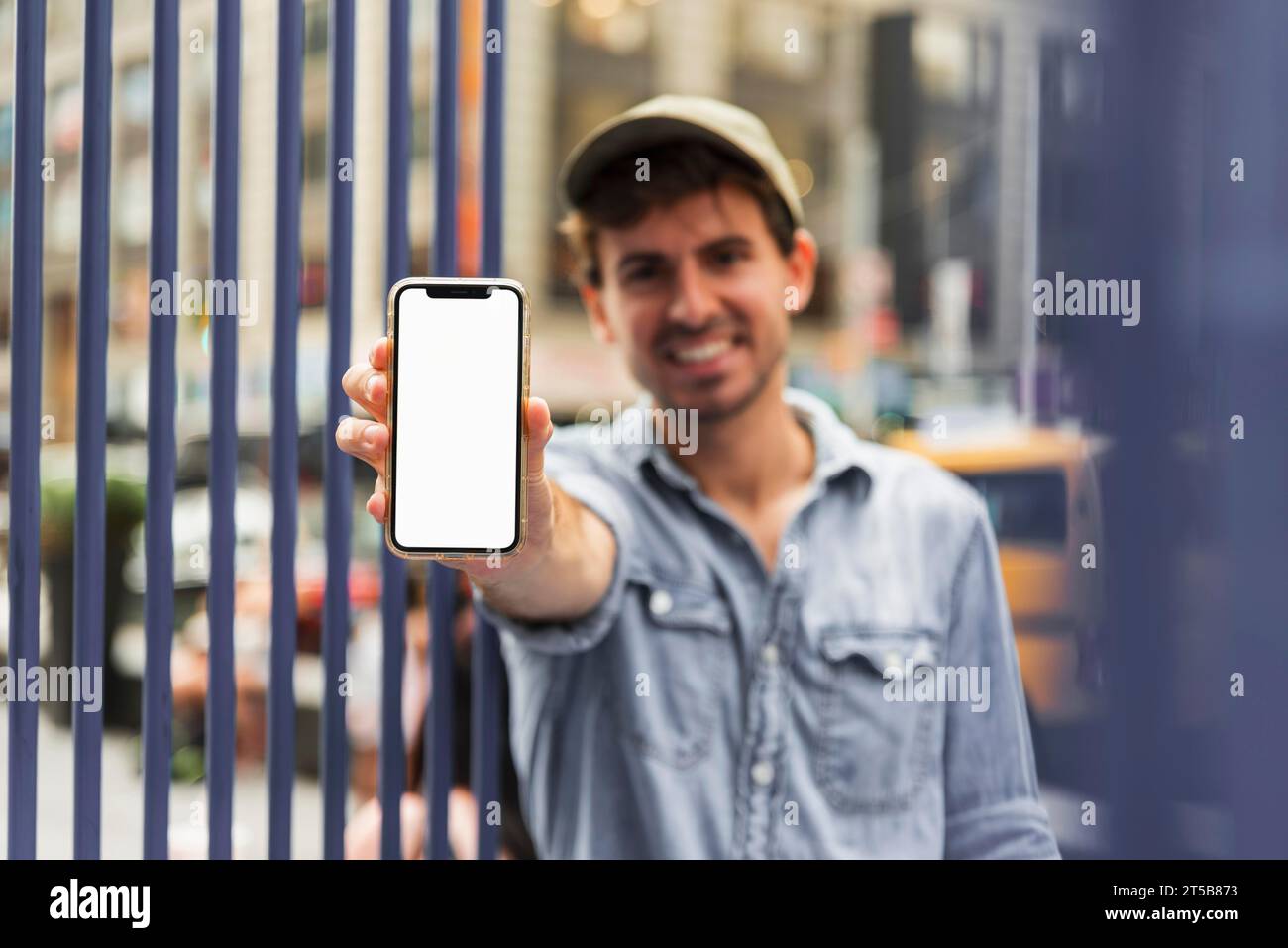 Ritratto maschio che tiene una fotocamera per l'aspetto di uno smartphone Foto Stock