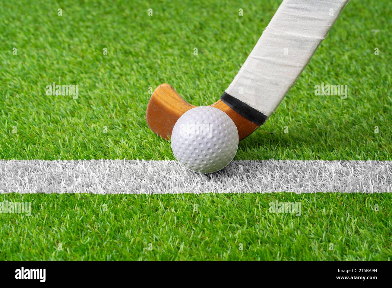 Campo con palla e bastone per hockey, fitness e allenamento nello stadio. Primo piano, terreno e attrezzature o attrezzature per una competizione, un gioco o un torneo a Foto Stock