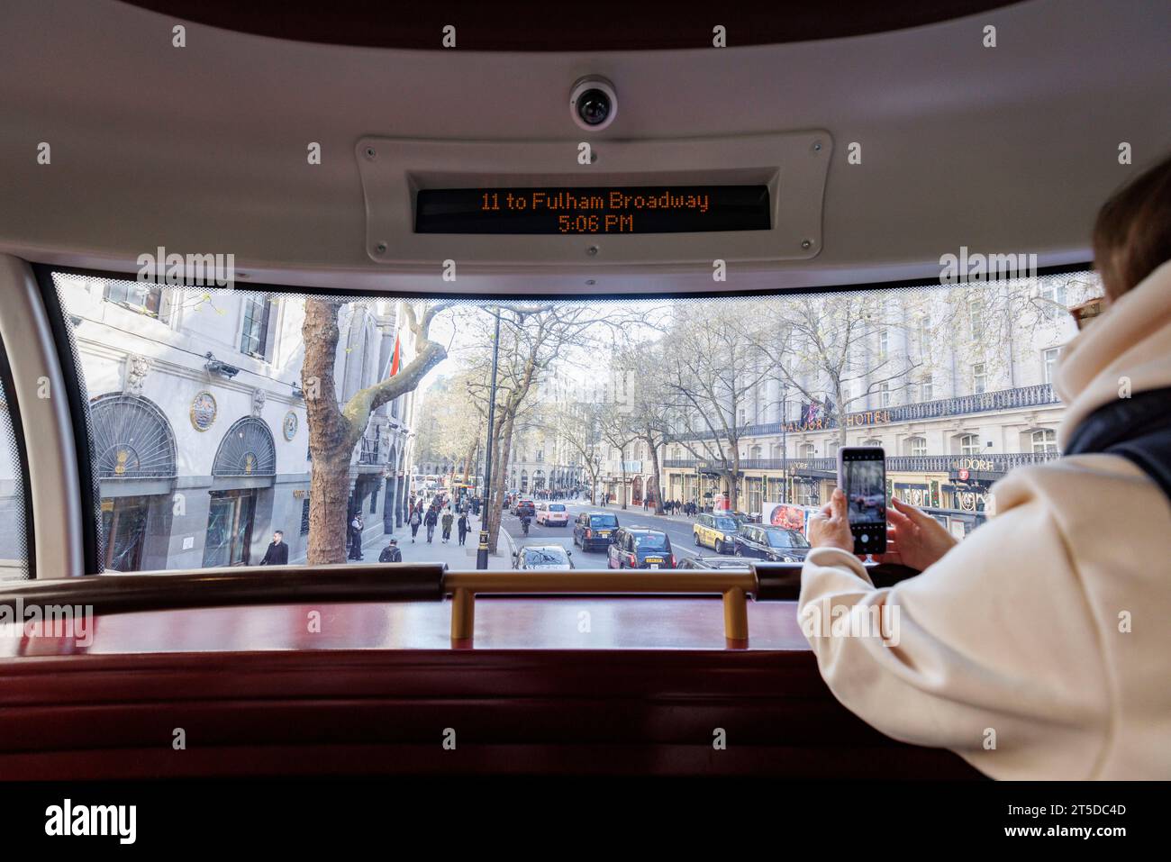 Sadiq Khan per raggiungere il punto di riferimento della linea 11 dell'autobus una settimana prima dell'incoronazione. Nella foto: Un turista scatta una foto sul suo telefono all'interno di un Bus 11 mentre passa Foto Stock