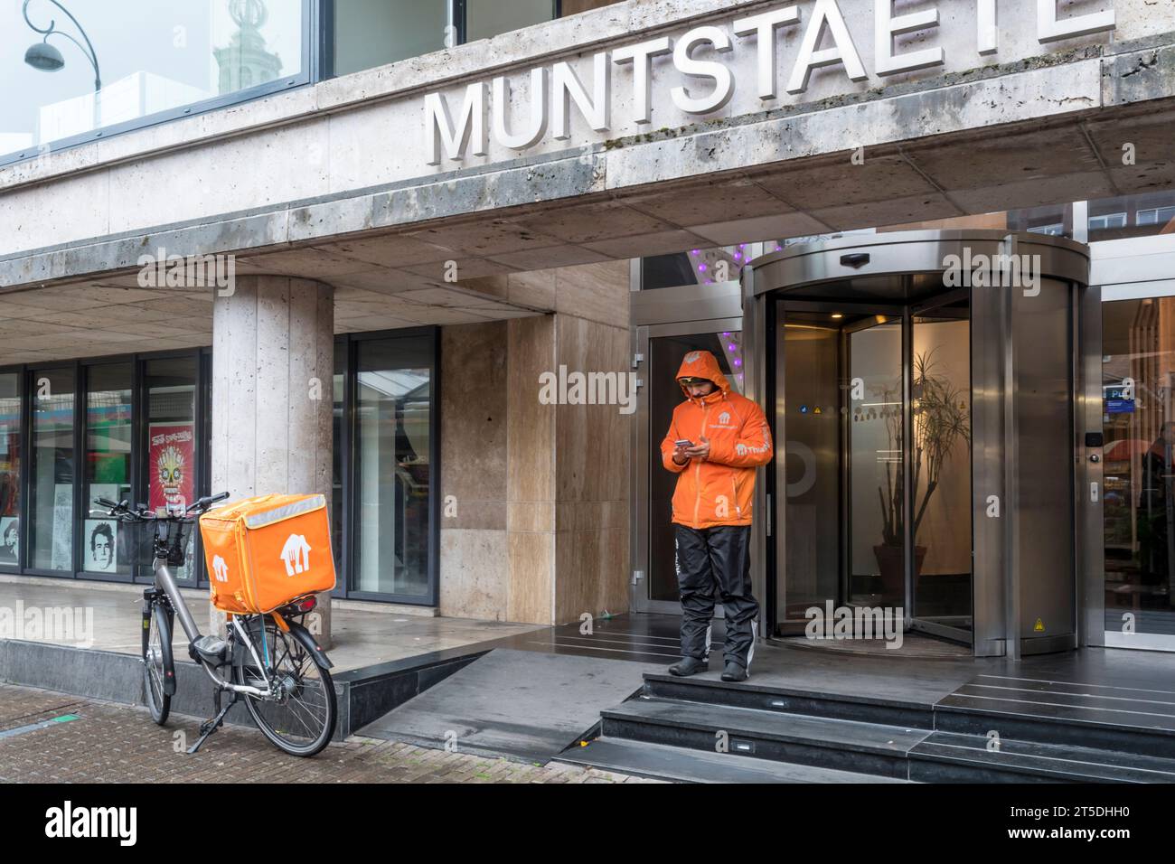 Corriere per Thuisbezorgd.nl, marchio originale olandese di Just Eat. Consegna in uffici condivisi nell'ex centro finanziario Muntstaete di Amsterdam. Foto Stock