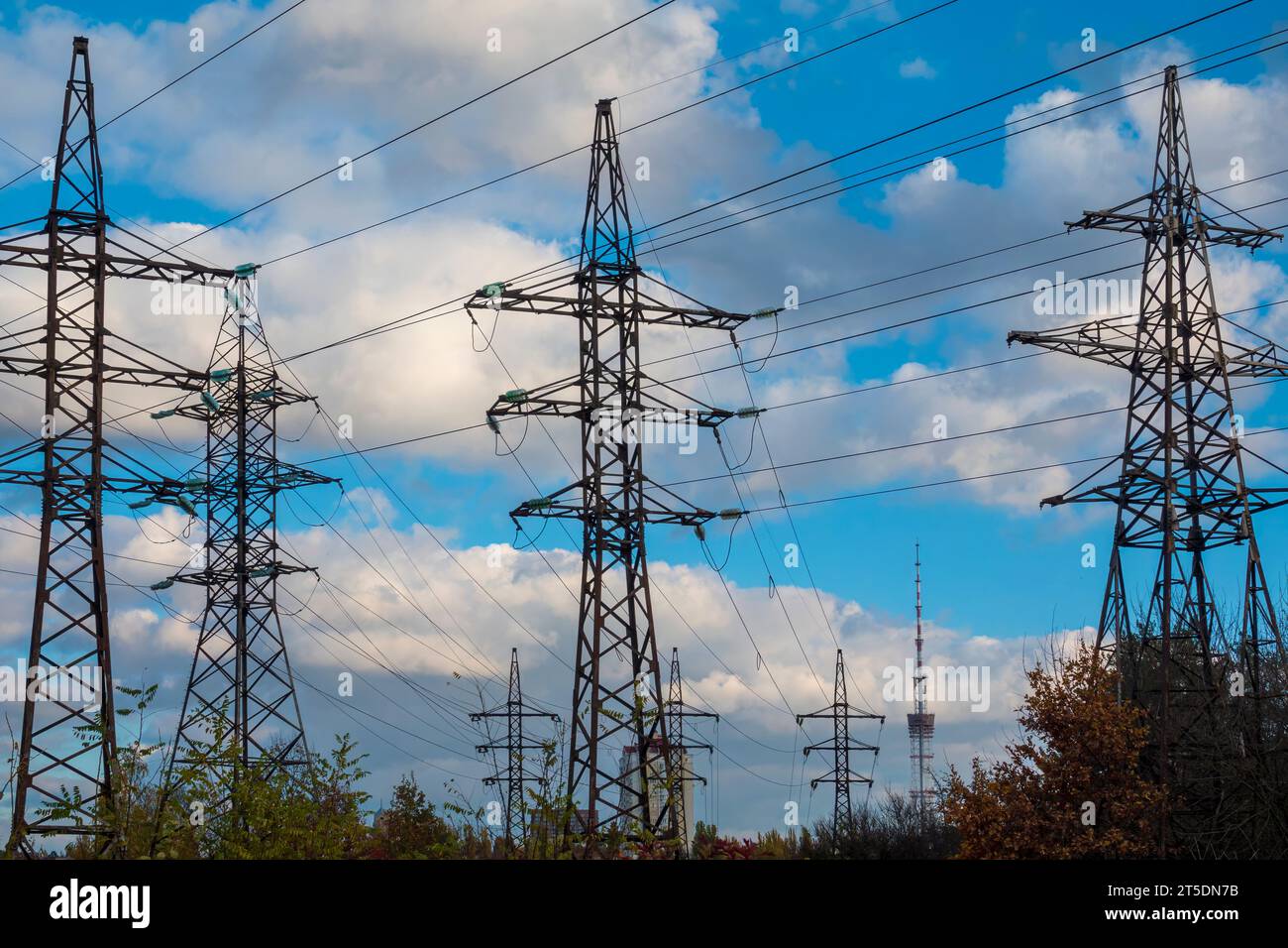 Torri di supporto per linee elettriche multiple contro il cielo blu con nuvole. Rete elettrica Foto Stock