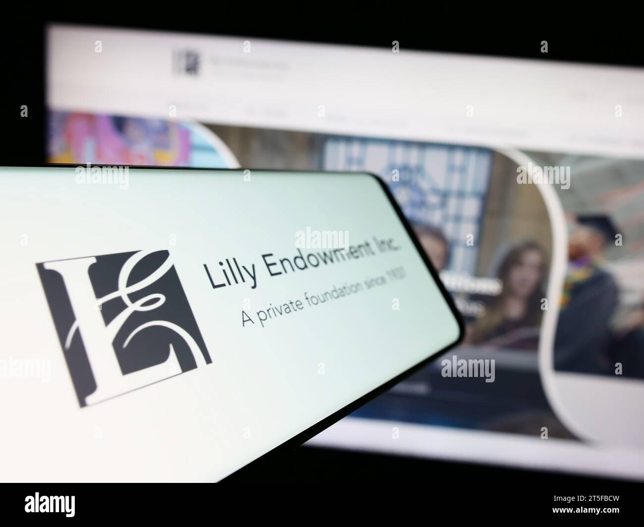 Cellulare con logo della fondazione statunitense Lilly Endowment Inc. Davanti al sito Web. Mettere a fuoco il display centrale sinistro del telefono. Foto Stock