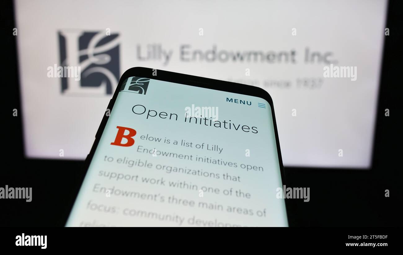 Telefono cellulare con pagina Web della fondazione statunitense Lilly Endowment Inc. Davanti al logo. Mettere a fuoco in alto a sinistra sul display del telefono. Foto Stock