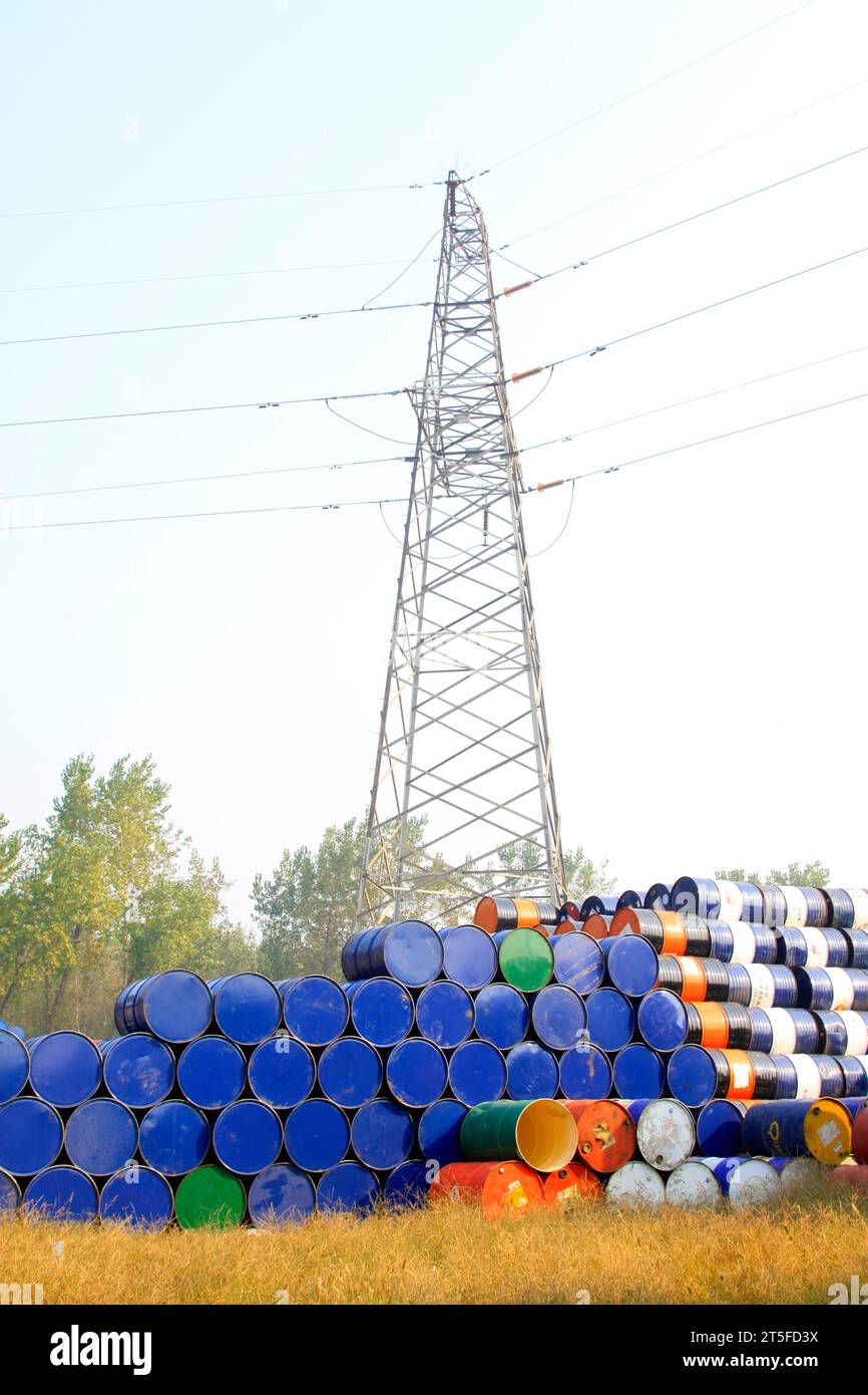 fusti di olio e torre elettrica in un'area di stoccaggio Foto Stock