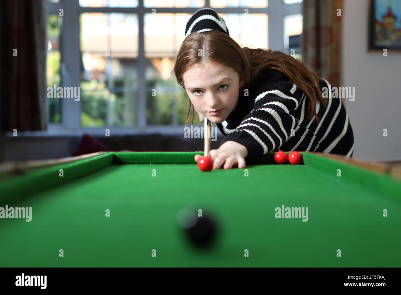 Adolescente che gioca a bagatelle in una tradizionale partita da pub nella sala a casa Foto Stock