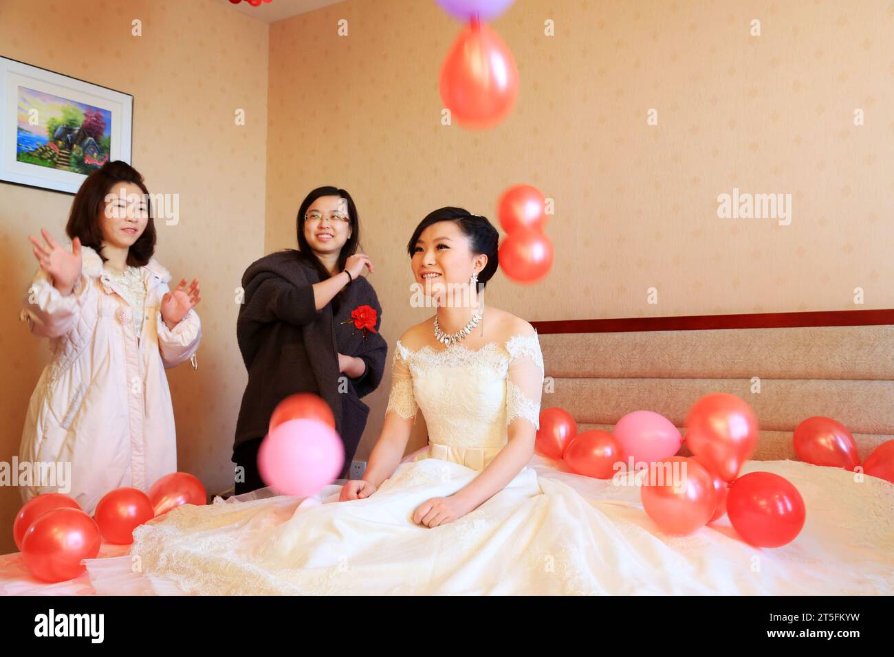 CONTEA DI LUANNAN - DICEMBRE 29: Gli amici lanciano palloncini rossi alla testa della sposa, sposa benedetta, costumi tradizionali nelle nozze cinesi, il 29 dicembre 201 Foto Stock