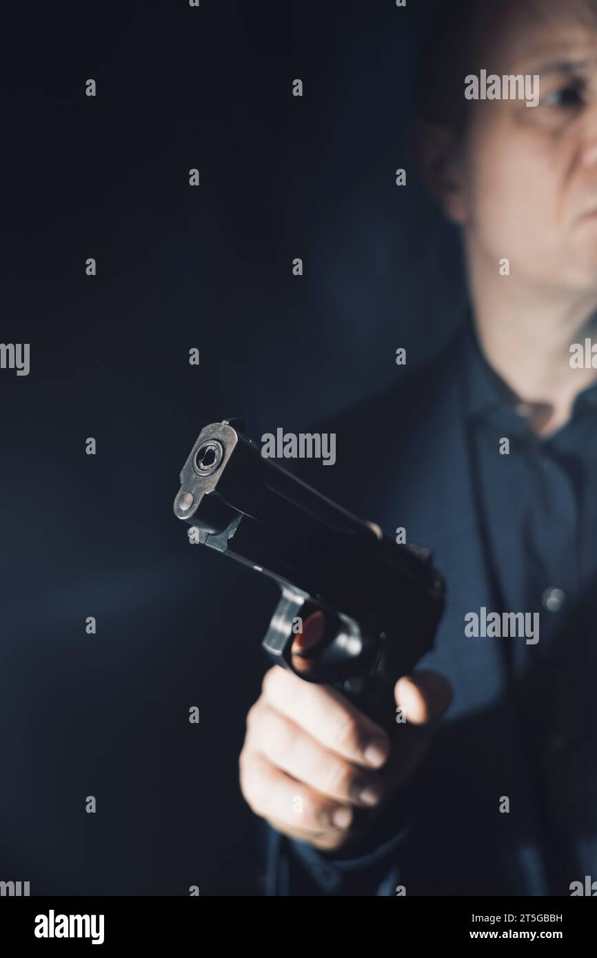 Il sicario mercenario spy assasin detective con un ritratto a pistola scattato in studio. Foto Stock