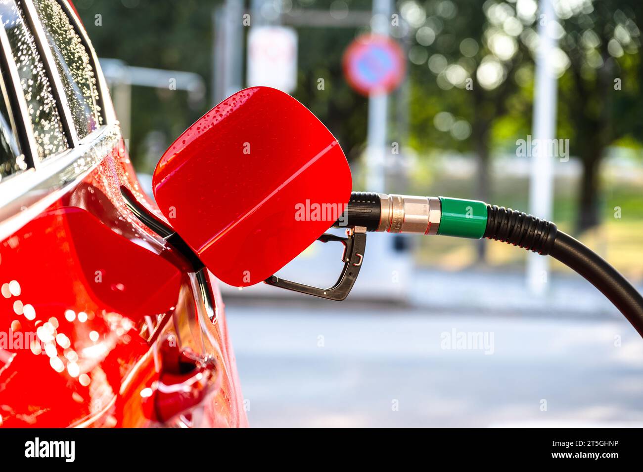 Auto rossa che si rifornisce di benzina in una stazione di servizio Foto Stock