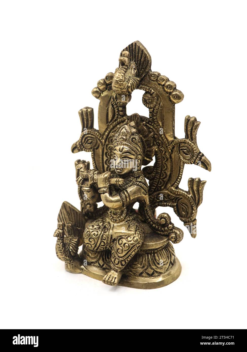 idolo decorativo in bronzo del dio indù krishna con un flauto seduto su un trono di pavone isolato su uno sfondo bianco Foto Stock