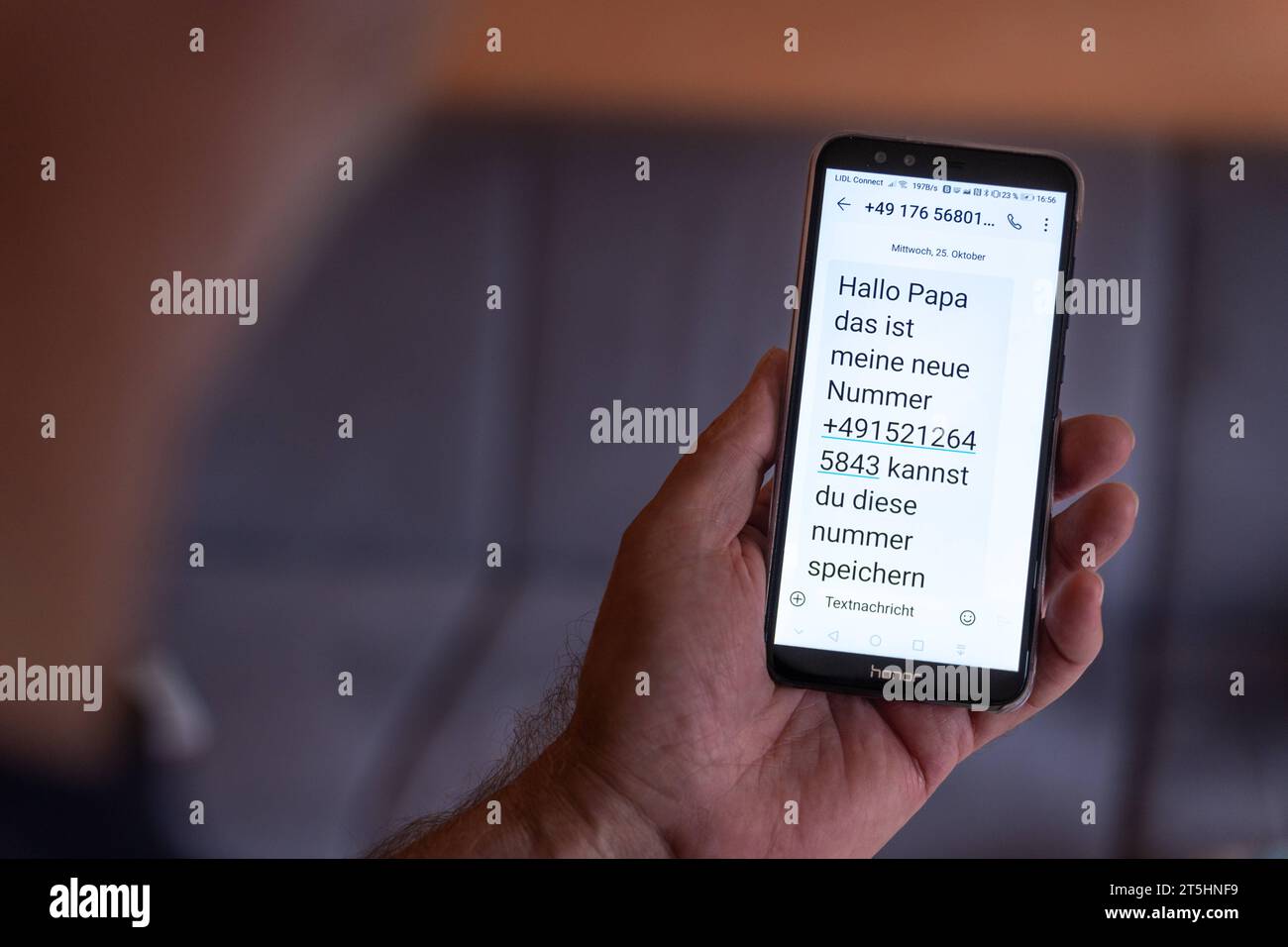 Augusta, Bayern, Deutschland - 27 ottobre 2023: Ein Alter Mann cappello eine SMS auf sein smartphone bekommen mit Text Hallo Papa das ist meine neue Nummer Ekeltrick und Telefonbetrug *** un vecchio ha ricevuto un messaggio di testo sul suo smartphone con il messaggio Ciao papà questo è il mio nuovo numero trucco disgustoso e frode telefonica credito: Imago/Alamy Live News Foto Stock