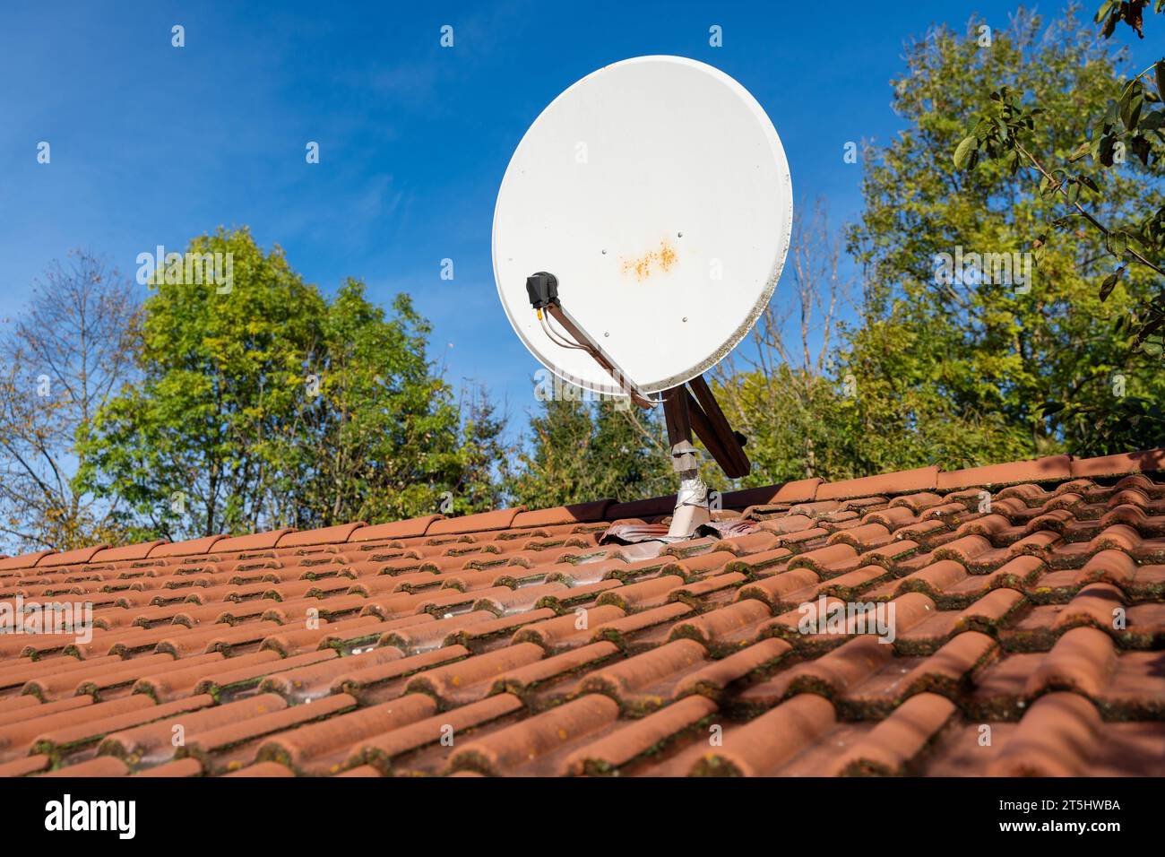 Bayern, Deutschland - 1 novembre 2023: Eine Satellitenschüssel auf einem Hausdach vor blauem Himmel. SAT-Empfang Konzept *** Una parabola satellitare sul tetto di una casa contro un cielo blu. Credito concetto ricezione SATELLITARE: Imago/Alamy Live News Foto Stock