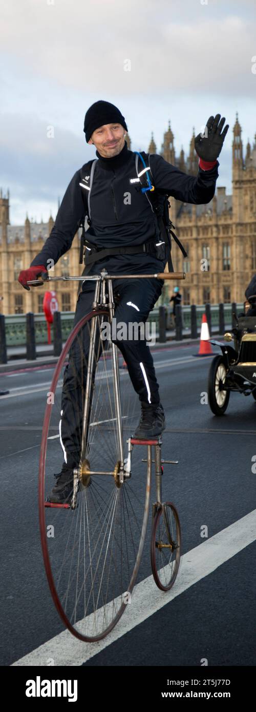 Partecipante ciclista Penny-Farthing sul Westminster Bridge di Londra fino alla corsa di auto veterane di Brighton Foto Stock
