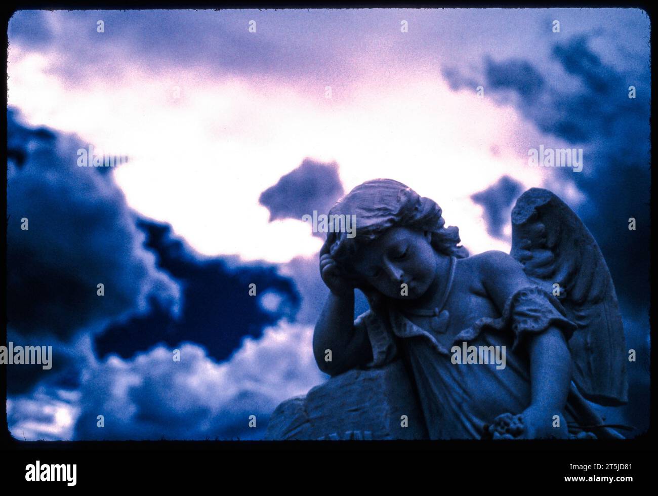 Angelo con un'ala rotta con nuvole di tempesta atmosferiche. Lapide fotografata con una pellicola A INFRAROSSI Kodak EIR EKTACHROME a Bodie, California. Foto Stock