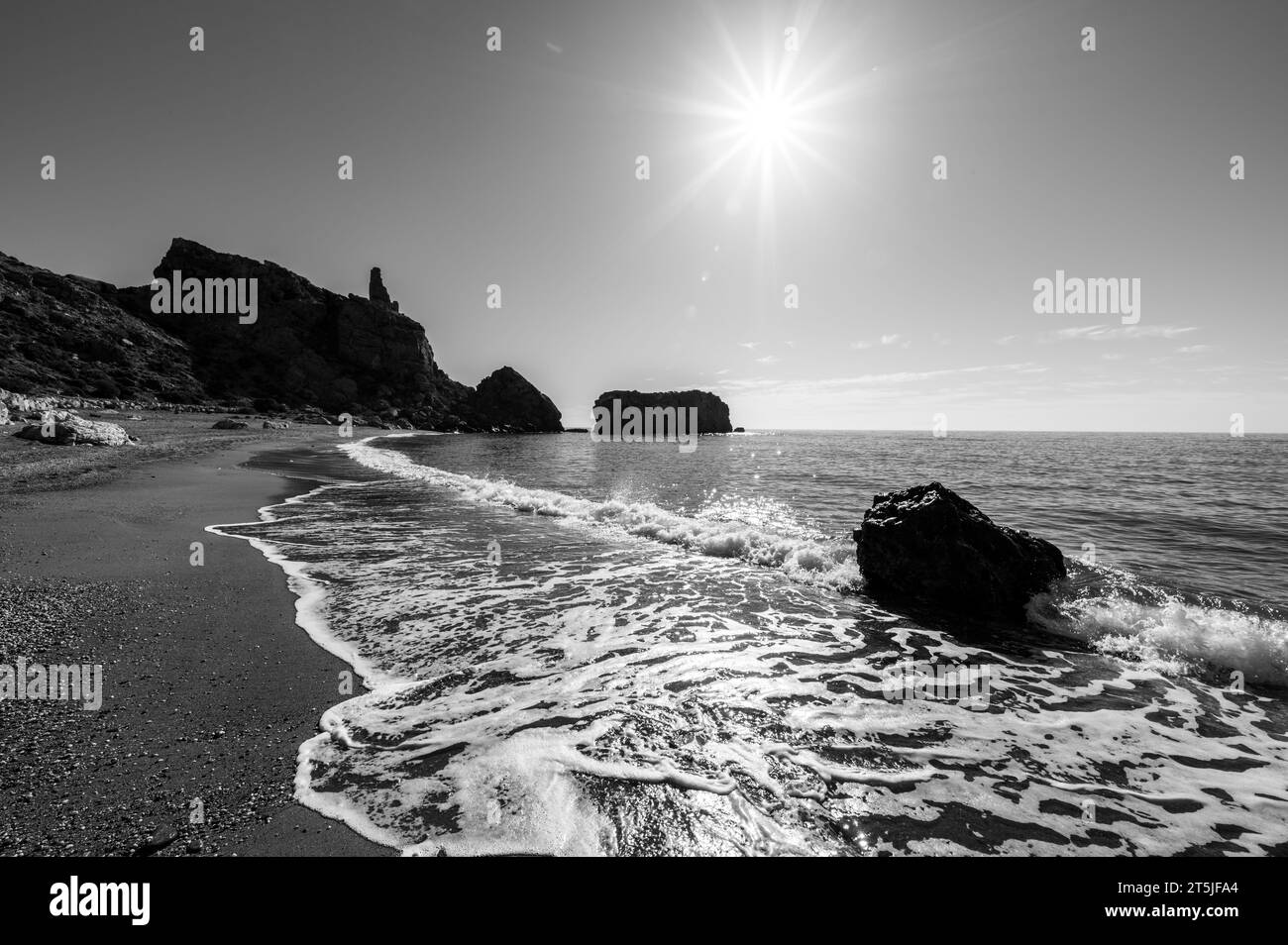 Vista panoramica in bianco e nero dal terreno di una graziosa spiaggia andalusa in una soleggiata mattinata autunnale Foto Stock