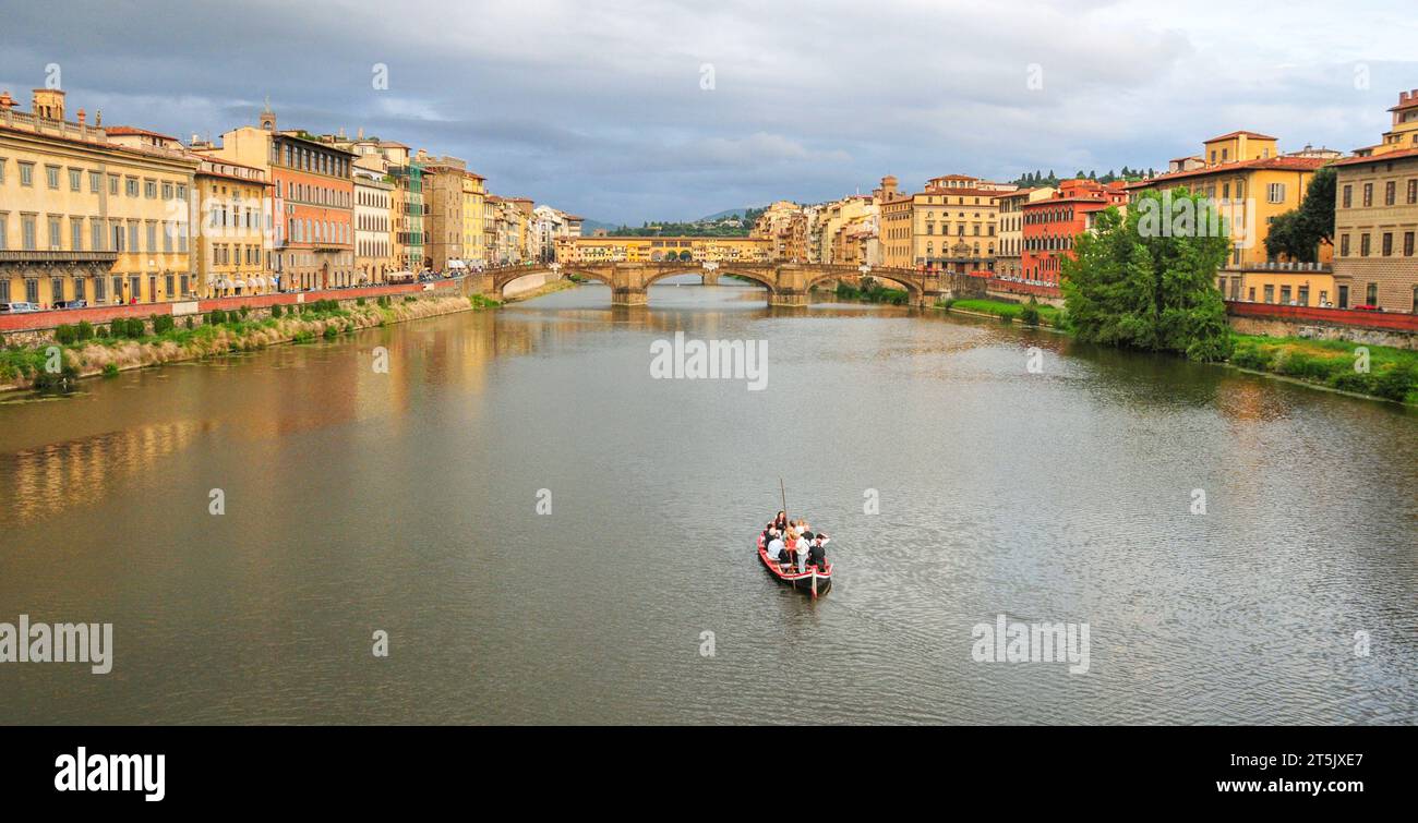 Firenze, Italia. 2013. I turisti in barca sull'Arno vicino al Ponte Vecchio con vecchi edifici sul bordo del fiume. Solo per uso editoriale. Foto Stock
