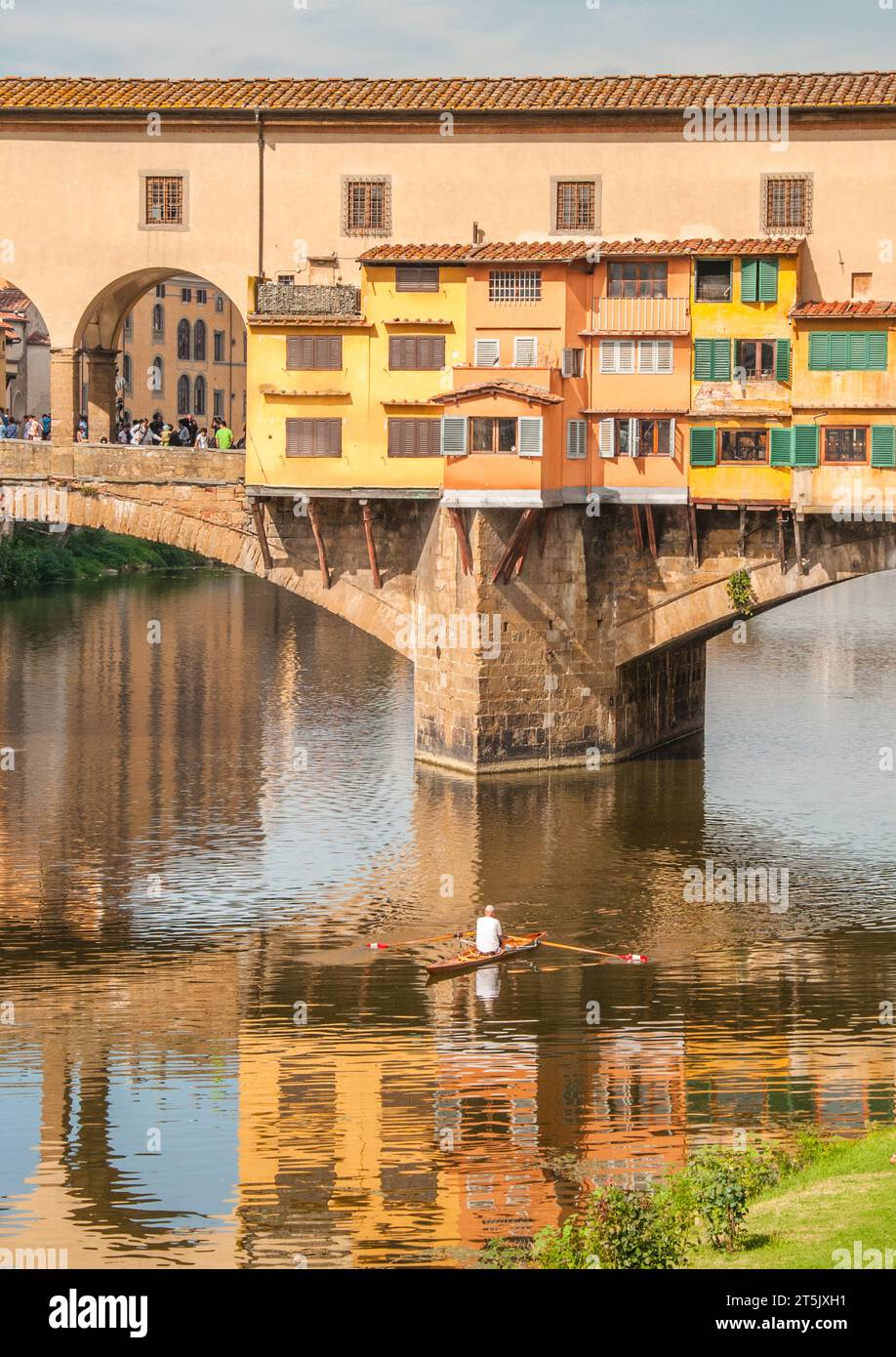 Firenze, Italia. 2013. Uomo in barca a remi sul fiume Arno sotto il Ponte Vecchio con un riflesso del ponte. Solo per uso editoriale. Foto Stock