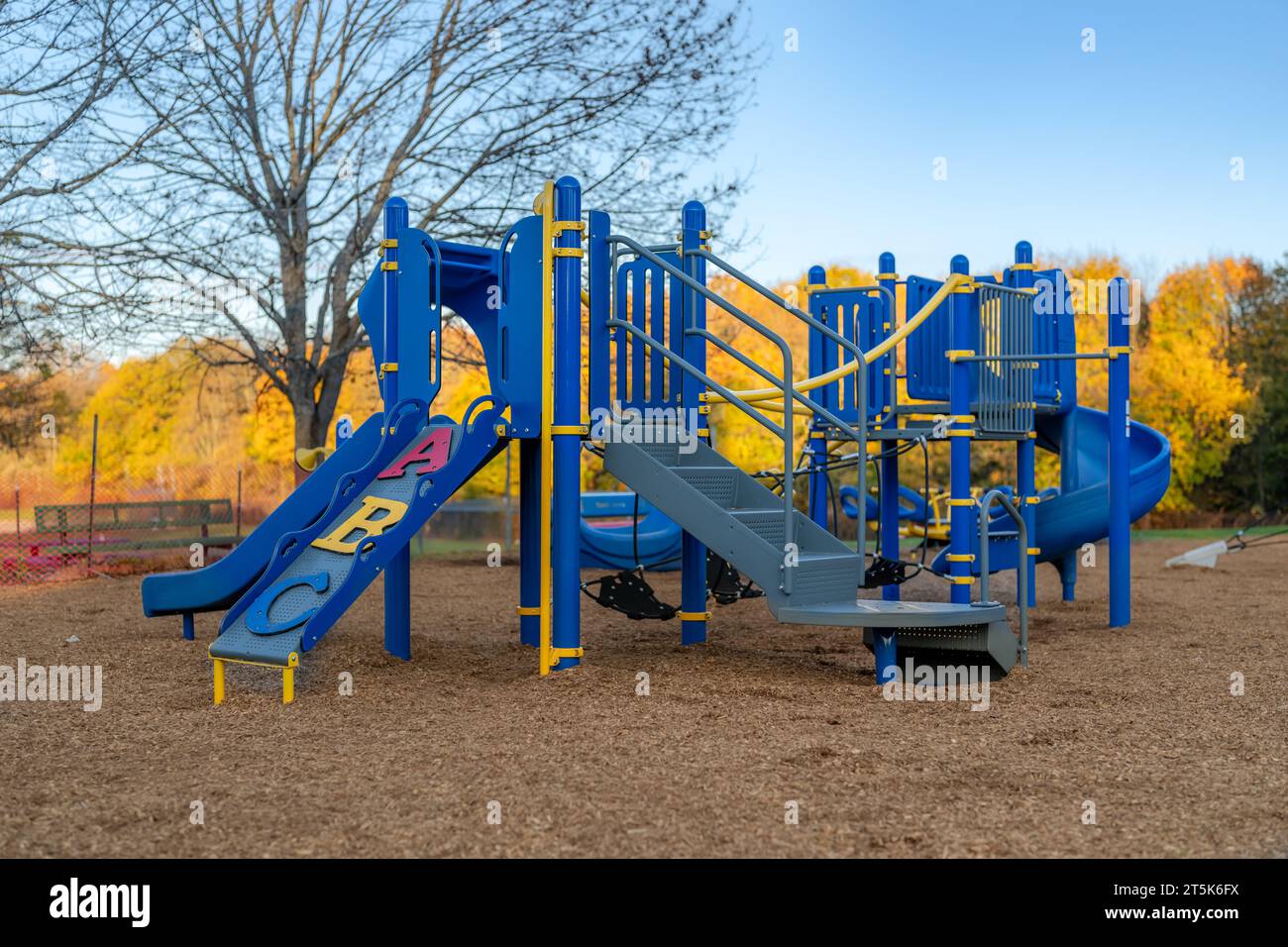 Tipico parco giochi per le scuole elementari non identificato con superficie anticaduta di sicurezza in fibra di legno Foto Stock