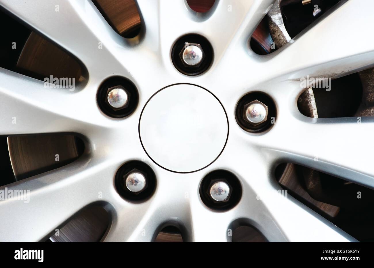 Primo piano di un coprimozzo grigio per auto con dadi cromati nel concetto di ricambi per auto Foto Stock
