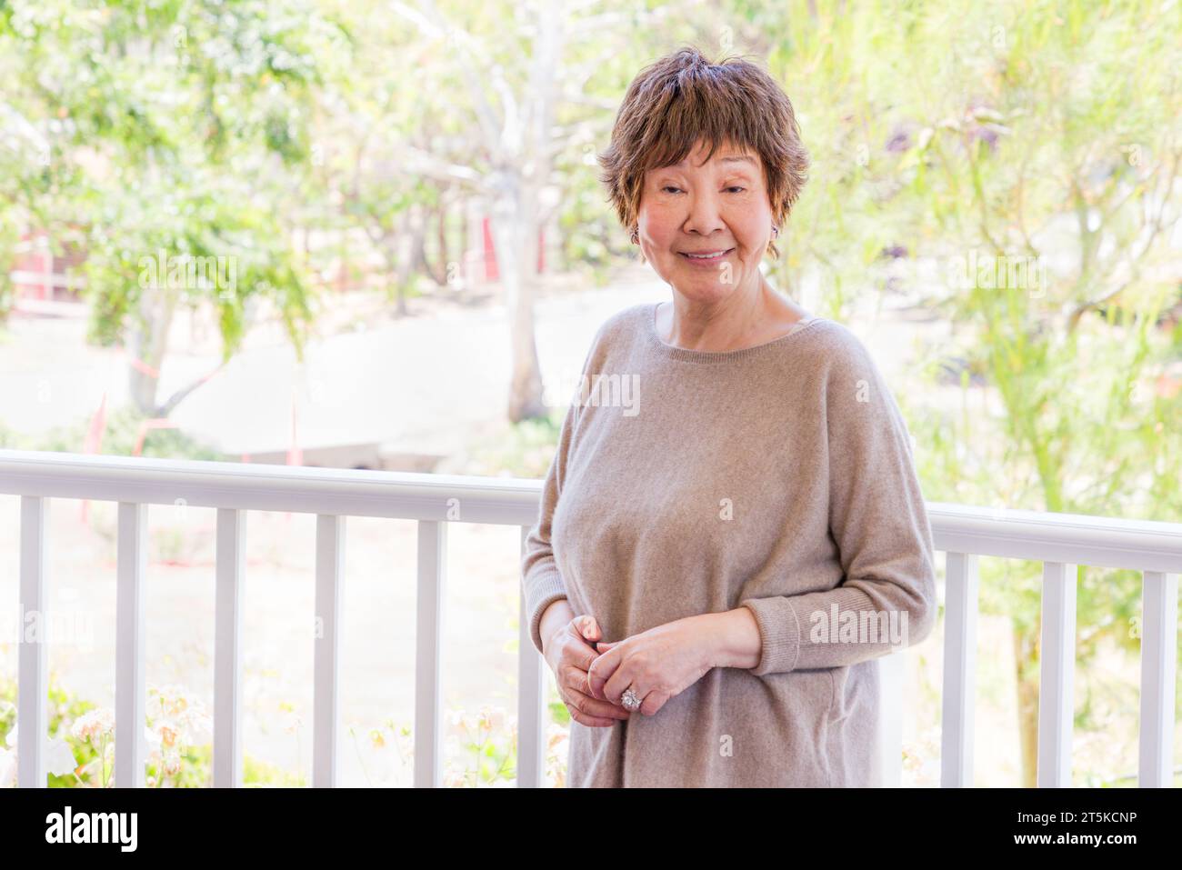 Una bella donna cinese anziana posa per il suo Ritratto all'aperto. Foto Stock