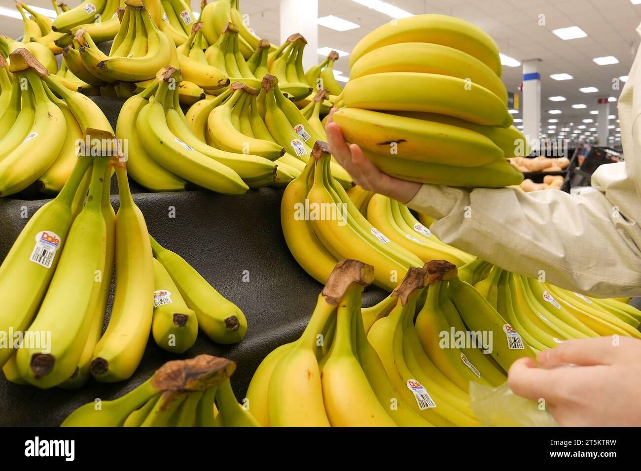 Donna che seleziona banana in un negozio Walmart Foto Stock