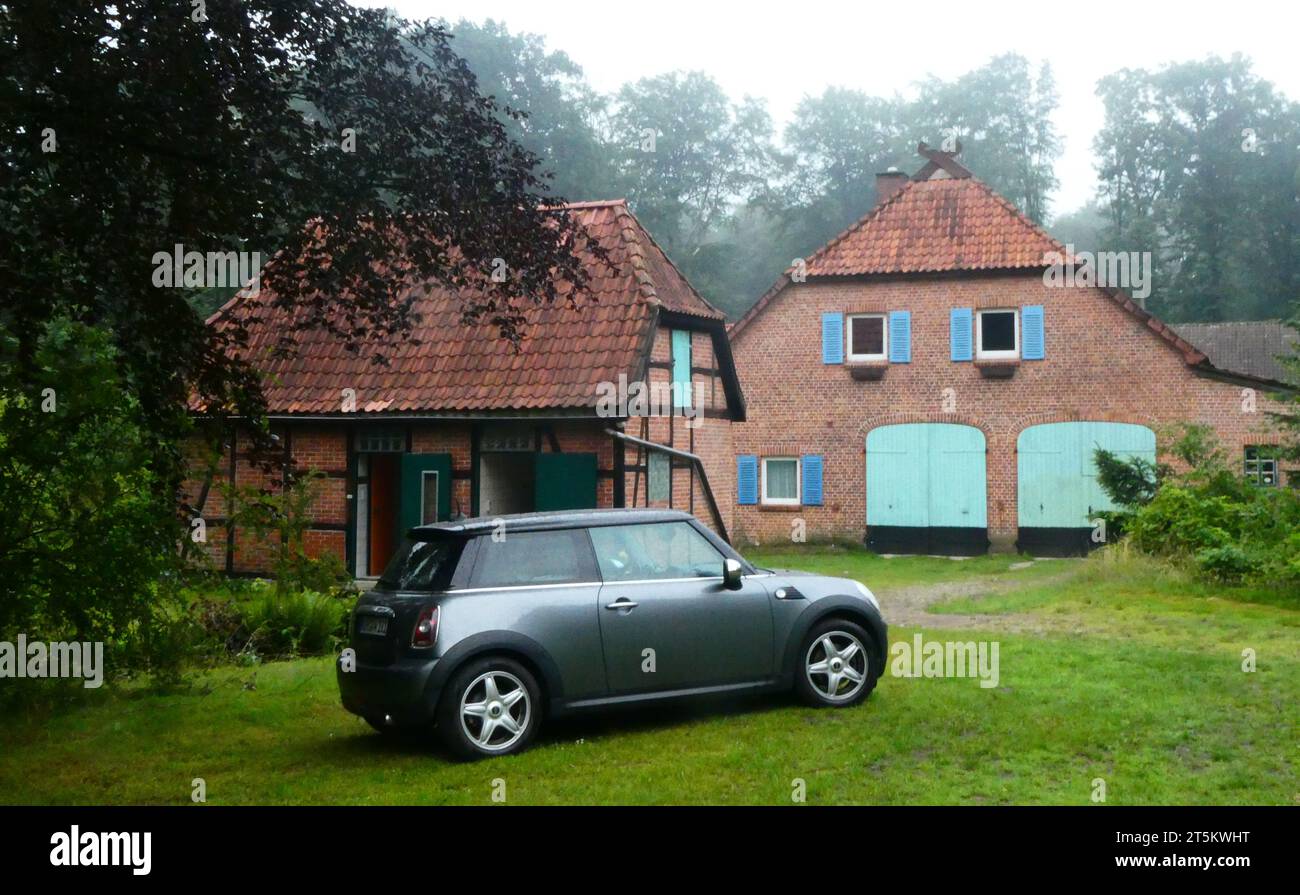 Schundingen, Germania - 10 luglio 2023 Una mini grigia si trova di fronte a una vecchia casa di un forestiere tedesco Foto Stock