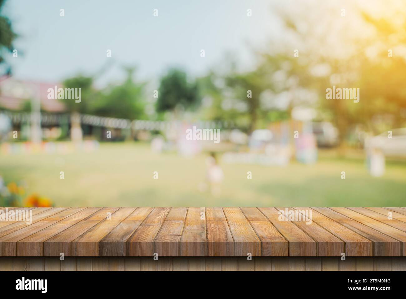 Tavolo in legno vuoto e giardino sfocato con montaggio per il prodotto Foto Stock