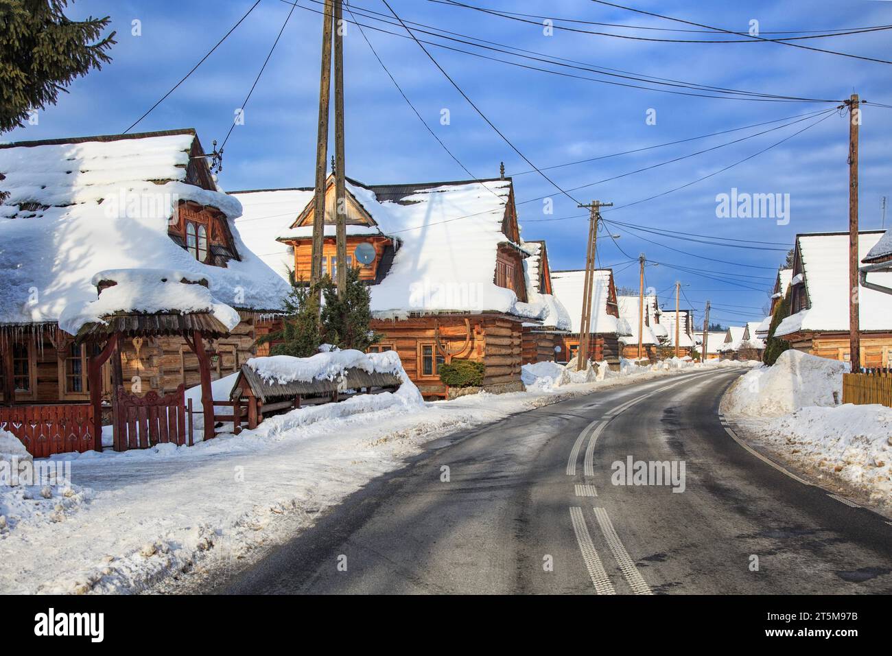 Strada invernale nella valle del villaggio polacco con vecchie case di legno. Tatra Mountains. Polonia Foto Stock