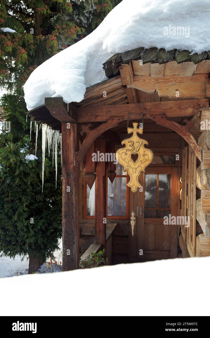 Vecchia casa in legno in uno splendido scenario invernale. Enormi ghiaccioli pendono dal tetto. Zakopane, Polonia Foto Stock