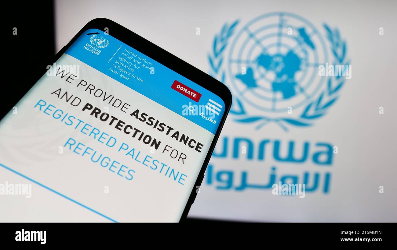 Telefono cellulare con il sito web dell'agenzia delle Nazioni Unite per i rifugiati plalestini UNRWA davanti al logo. Mettere a fuoco in alto a sinistra sul display del telefono. Foto Stock