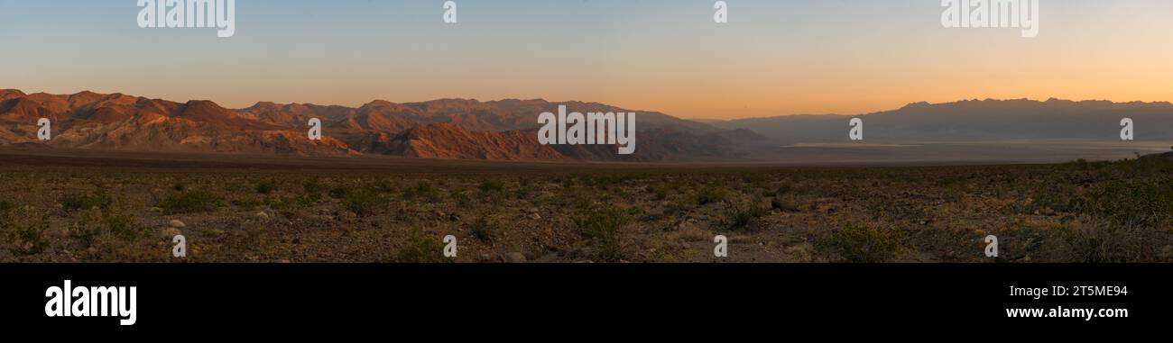 Una vista panoramica della desolata Valle della morte ad ovest degli appartamenti di Mesquite, nel campeggio Emigrant, all'alba, toni arancioni nel cielo. Picco Grapevine. Foto Stock