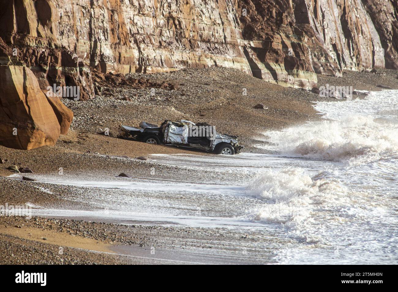 Sidmouth, 6 Nov 23 i resti di un pick-up spazzato via in mare dal lungomare di Sidmouth durante la tempesta Ciaran ora si sono riversati lungo la spiaggia. Il veicolo è ora situato sotto le pericolose scogliere in rovina a est della città, pertanto non sono attualmente in atto piani per il recupero del veicolo. Non si sa chi sia il proprietario del veicolo. Photo Central, Alamy Live News Foto Stock