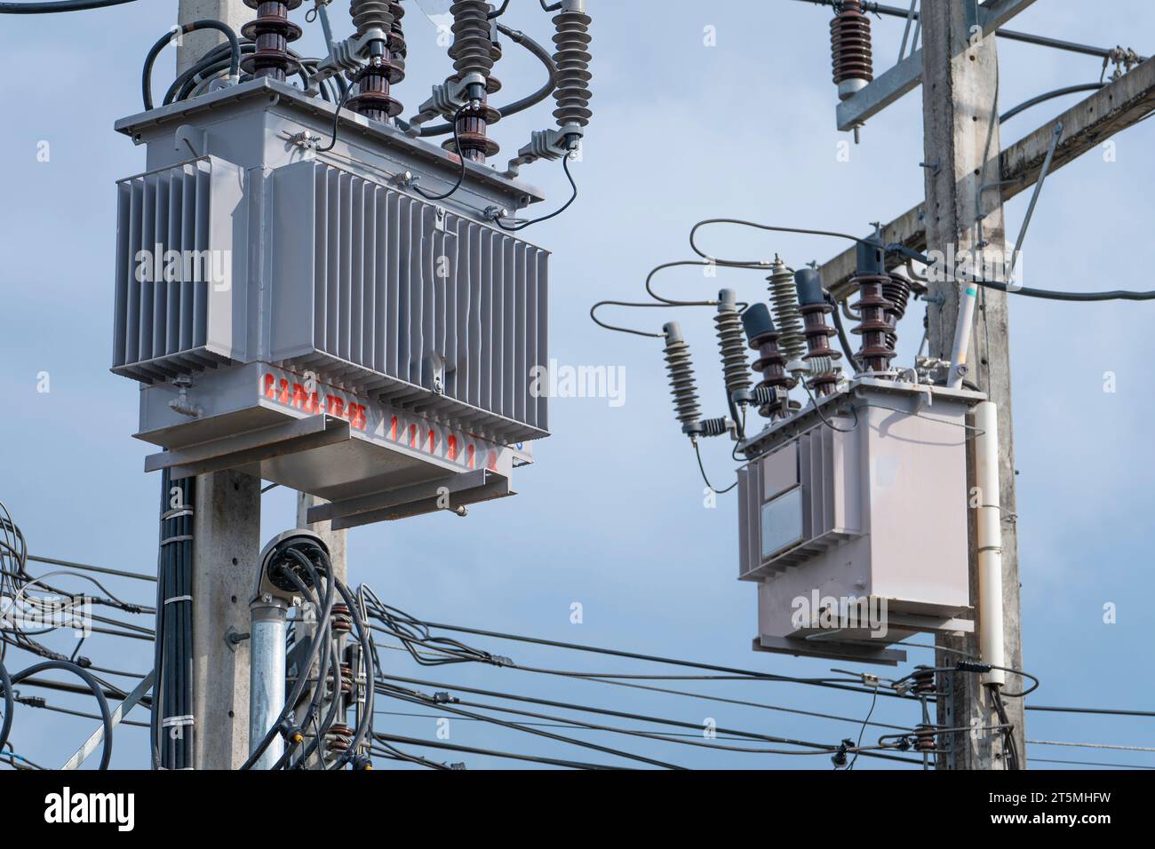 Trasformatori elettrici su un polo di alimentazione in Thailandia, alta tensione e alimentazione Foto Stock