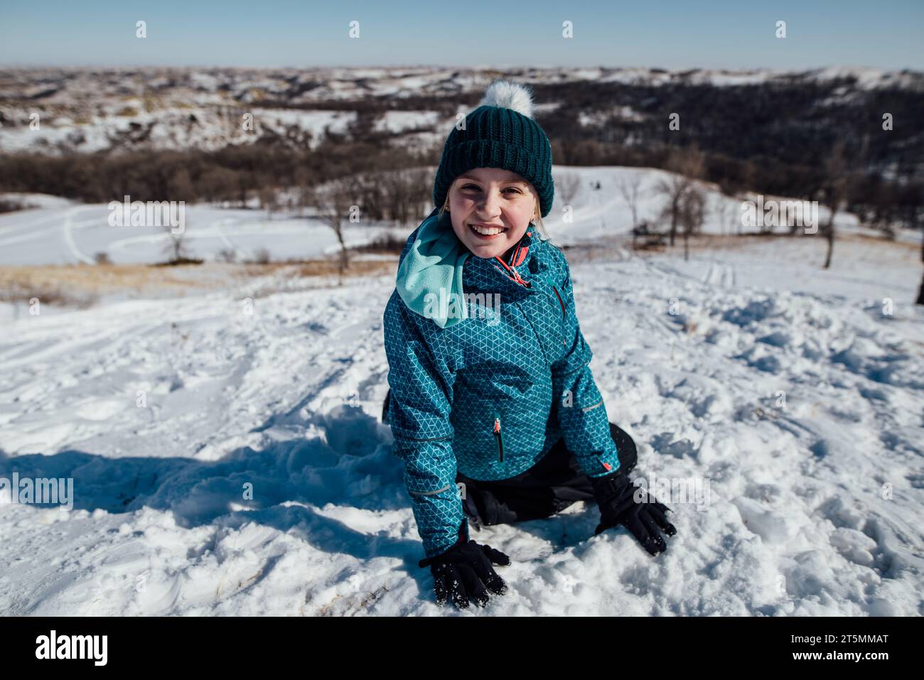 Vista ravvicinata di una ragazza ofreteen seduto su un terreno innevato e guardando Foto Stock