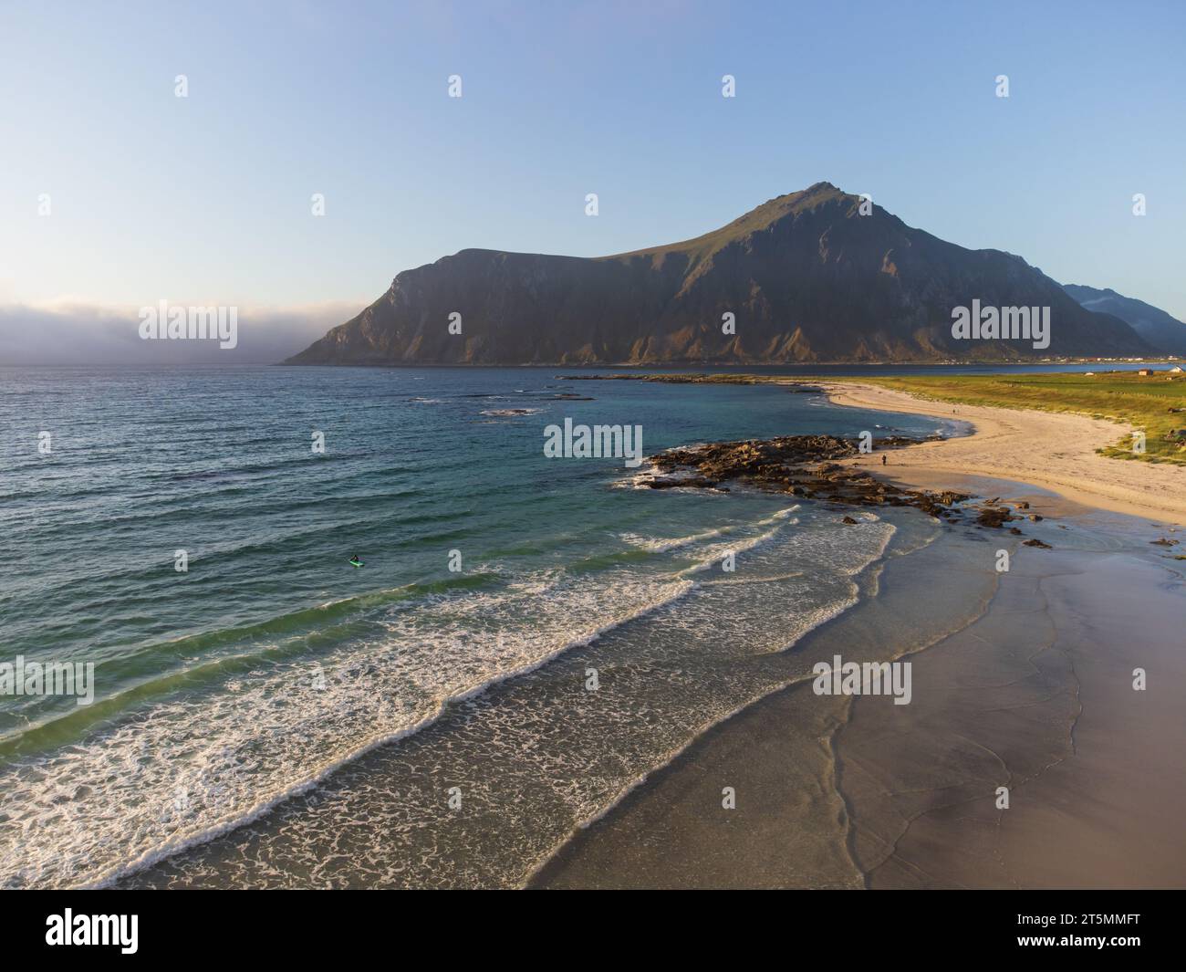 Vista dei surfisti e della spiaggia di Lofoten, Norvegia, sotto il sole di mezzanotte. Foto Stock