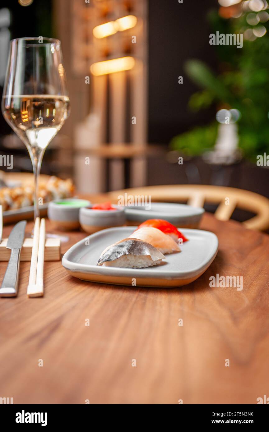 Set di nigiri: Sgombro, spigola, salmone su un piatto su un tavolo in un sushi bar su un piatto da vicino. Foto di alta qualità Foto Stock
