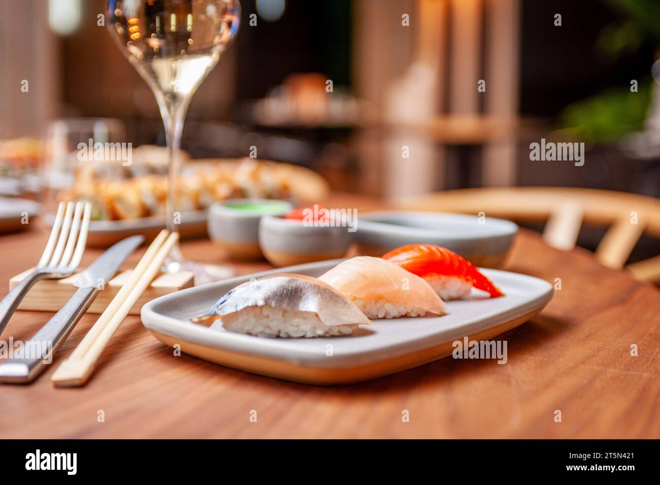 Set di nigiri: Sgombro, spigola, salmone su un piatto su un tavolo in un sushi bar su un piatto da vicino. Foto di alta qualità Foto Stock