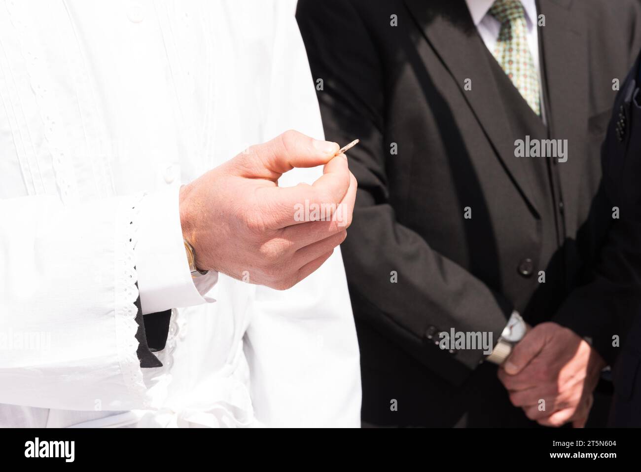 Uno sposo mostra l'anello che ha acquistato per la sua sposa durante lo scambio o la cerimonia degli anelli di un matrimonio ebraico. Foto Stock