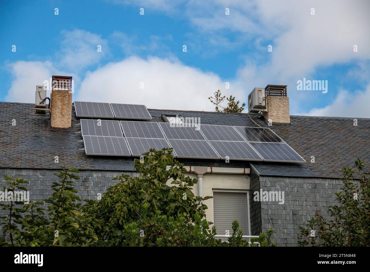 Pannelli solari fotovoltaici installati su un tetto in ardesia Foto Stock