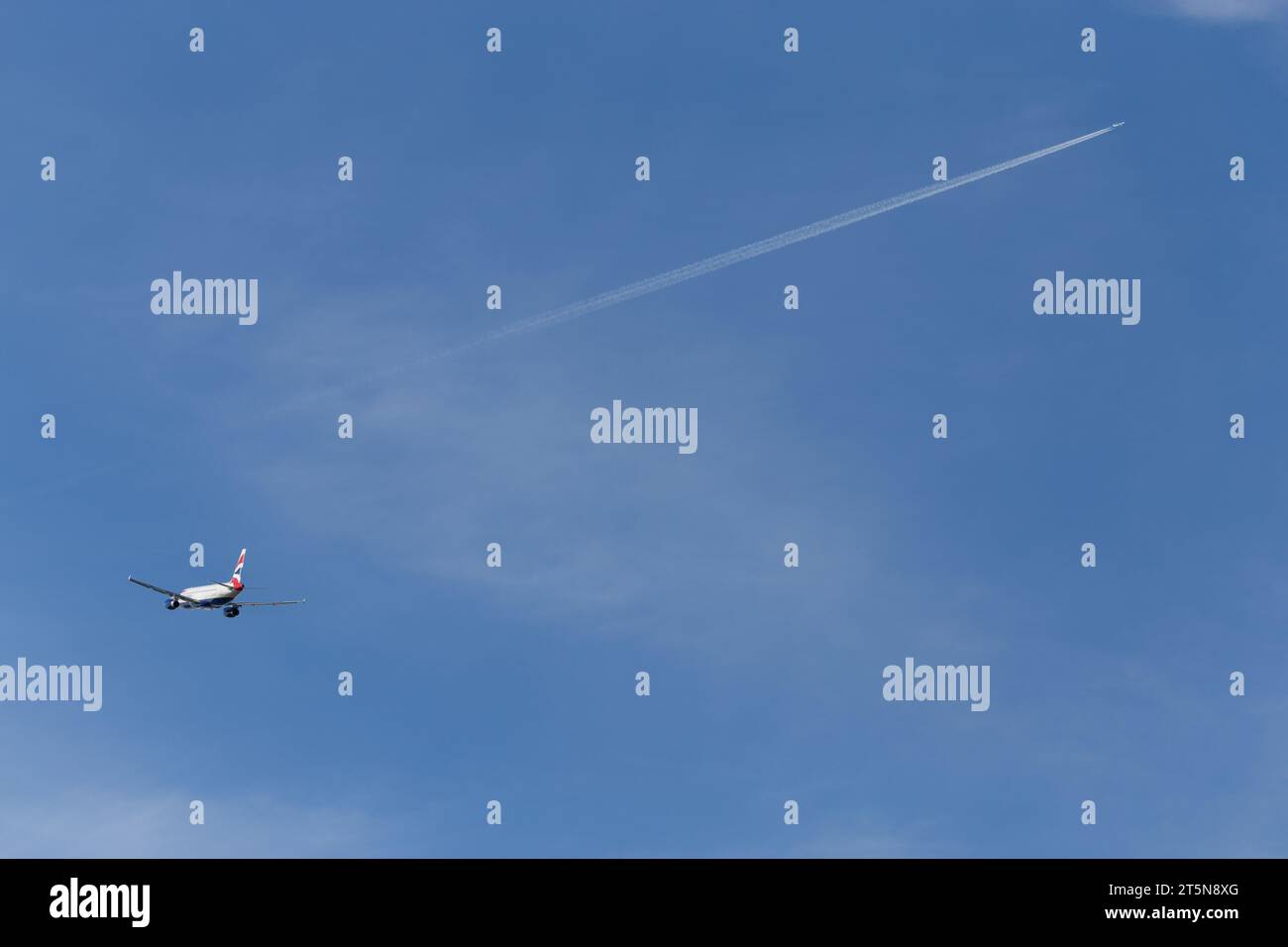 British Airways Airbus A320-232, immatricolazione G-EUYH in partenza da Londra Heathrow in un soleggiato tardo pomeriggio con un contrail e un altro aereo in lontananza Foto Stock